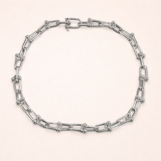 Silver chain necklace on a light beige background